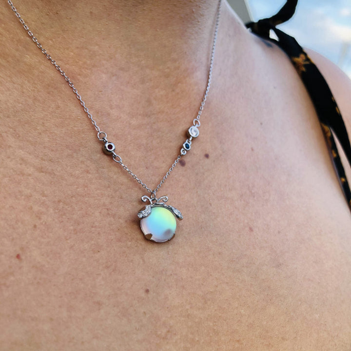 Magical women's moonstone necklace with a delicate firefly pendant, elegant silver jewelry.
