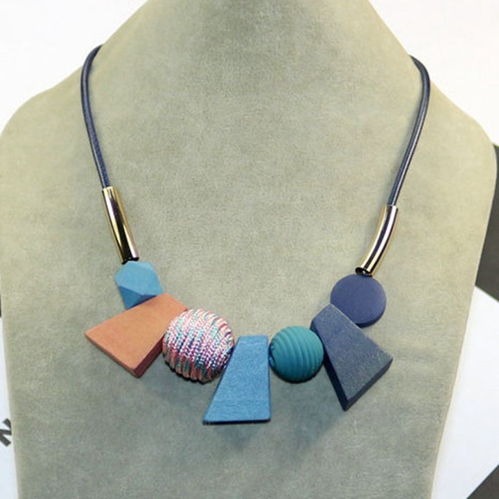 Detailed view of women's geometric wooden bead necklace. Ethnic handmade natural wood accessory.
