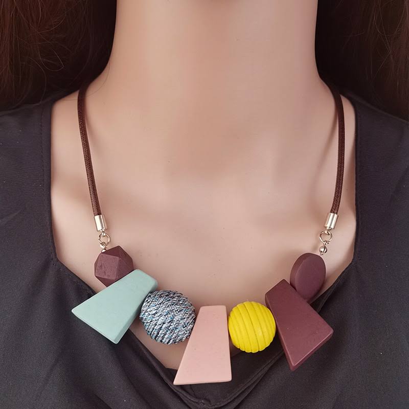 Handmade ethnic geometric wooden bead necklace for women. Natural wood, boho fashion statement piece.