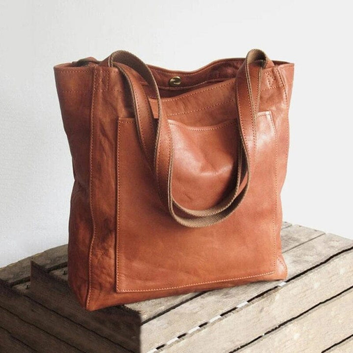 Spacious women's vegan leather tote bag with organized compartments, ideal for work and travel.
