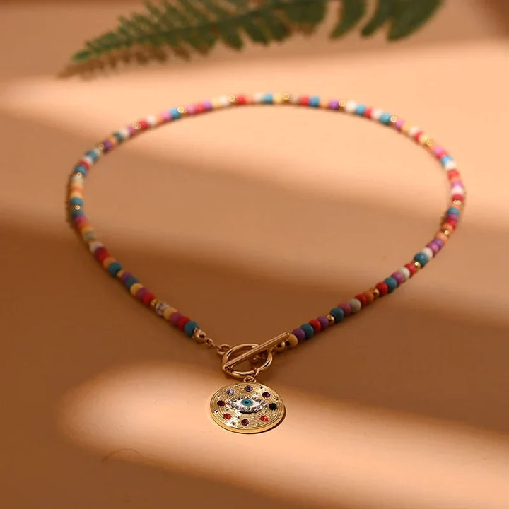Stylish women's pearl choker necklace with blue evil eye charm, offering protection & fashion.