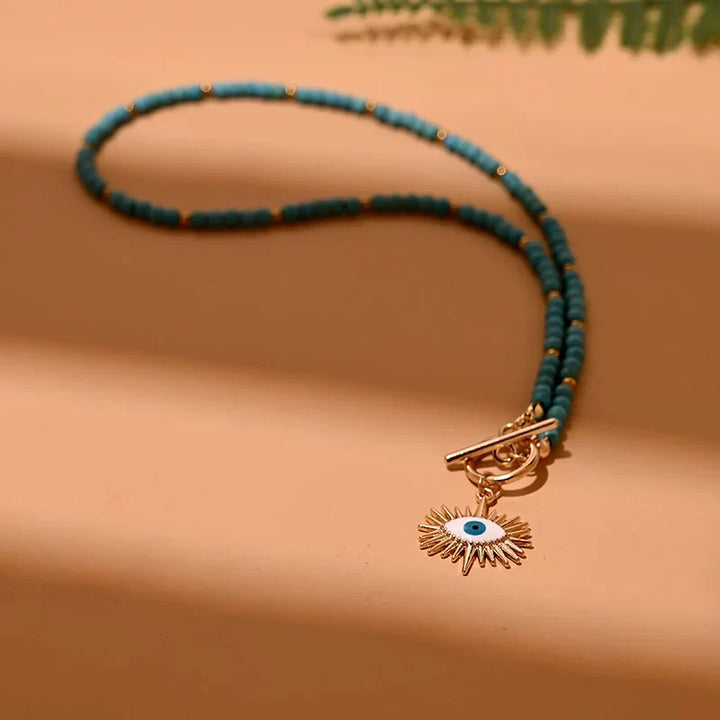 Classic women's pearl choker necklace with a striking evil eye charm, spiritual protection jewelry.
