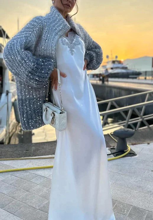 Elegant women's knitted cardigan featuring festive sequins. Long-sleeve sparkle top, perfect for glamorous party fashion.