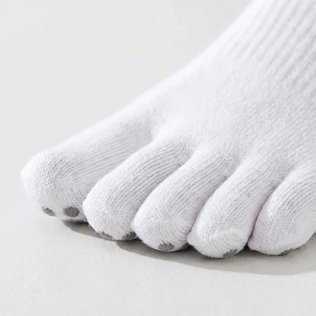 Woman wearing five-toe grip yoga socks during a pilates session. Non-slip athletic socks provide stability & comfort.