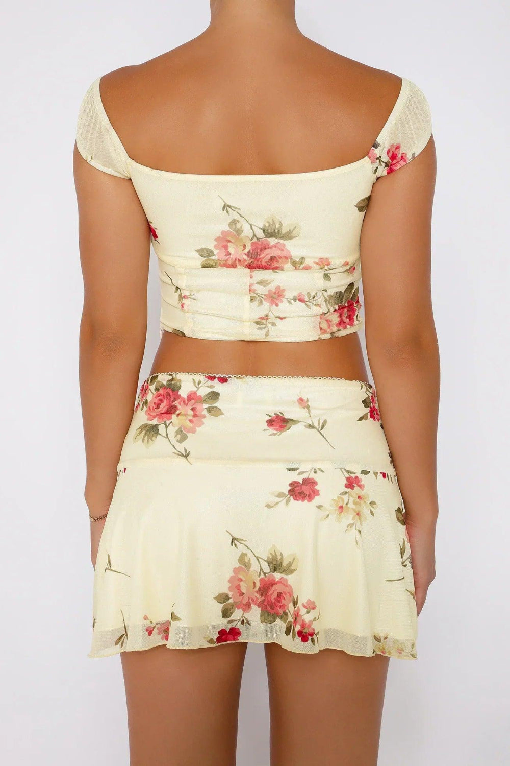 Playful women's two-piece floral print crop top and mini skirt, ideal for beachwear.