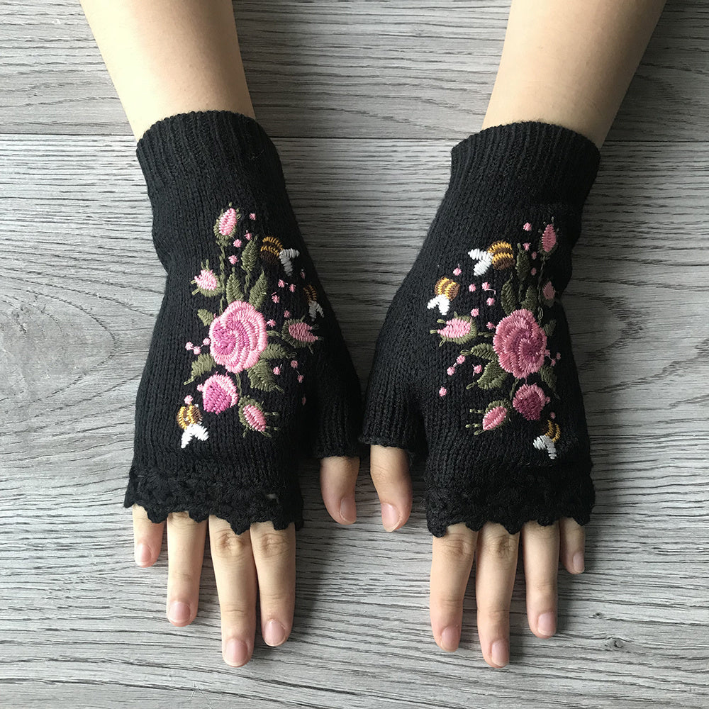 Close-up of vibrant floral embroidery on soft knit women's fingerless gloves.