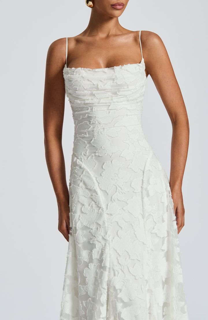Woman wearing a flowy floral maxi dress, showcasing its elegant movement and A-line cut.