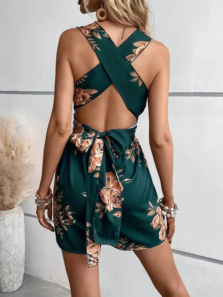 Vibrant floral print women's romper with a distinctive open back & flattering halter neckline.