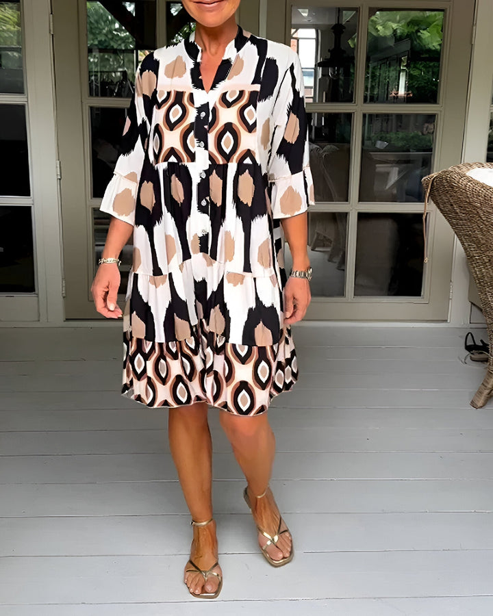 Women's flowing bohemian tiered dress with vibrant geometric print, ruffle sleeves, and mandarin collar, perfect for summer.