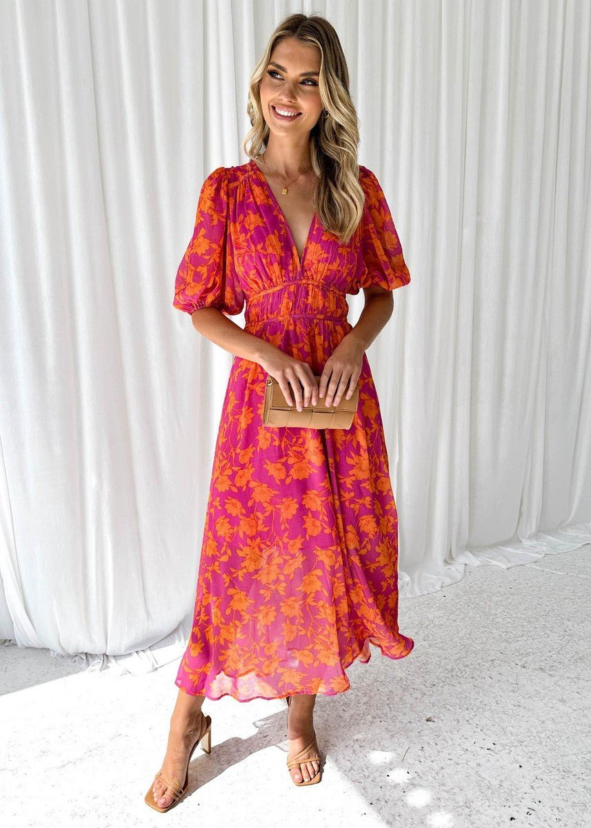 Women's flowing pink orange floral maxi dress with V-neck & puff sleeves, perfect for summer vacations or elegant brunch.