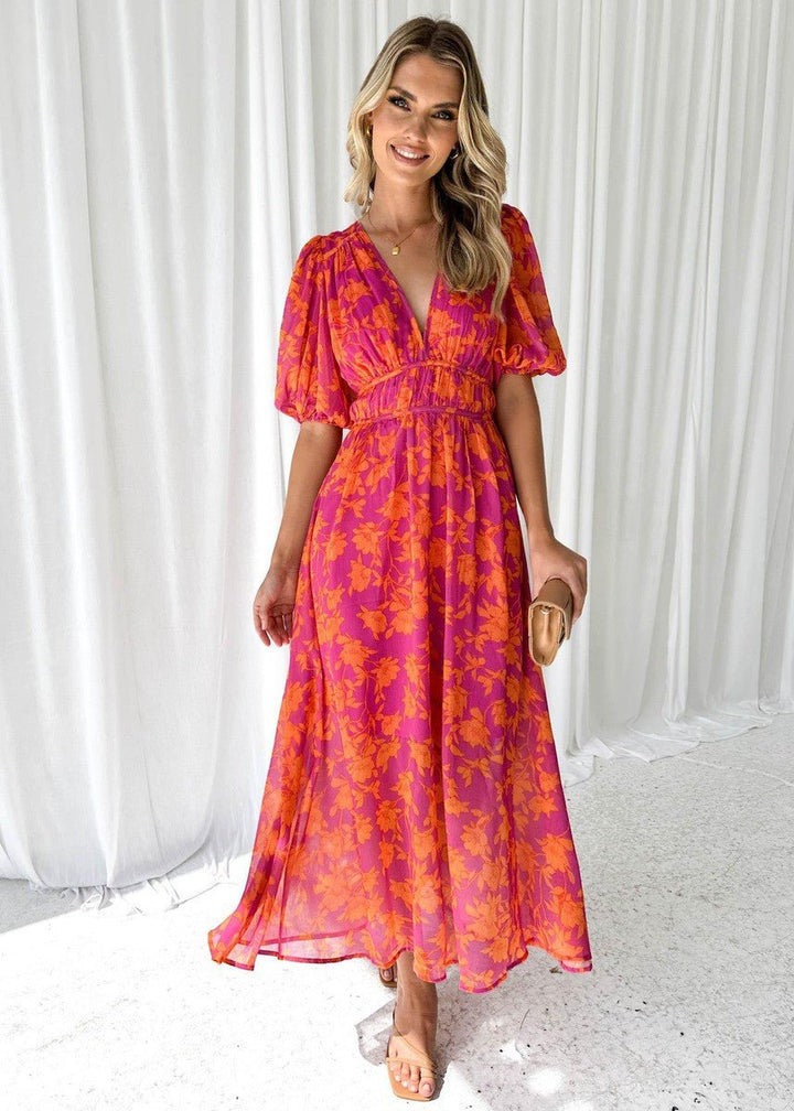 Beautiful women's pink orange floral maxi dress, showcasing a vibrant pattern, flowing silhouette & stylish puff sleeves.