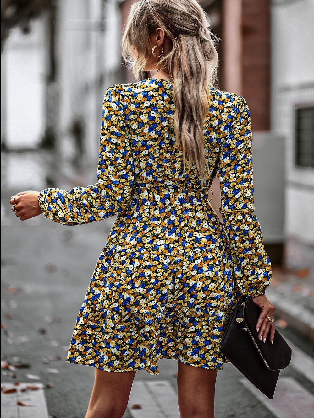 Yellow women's flowing mini dress with ruffles & belt. Stylish V-neck summer outfit for vacation or casual wear.