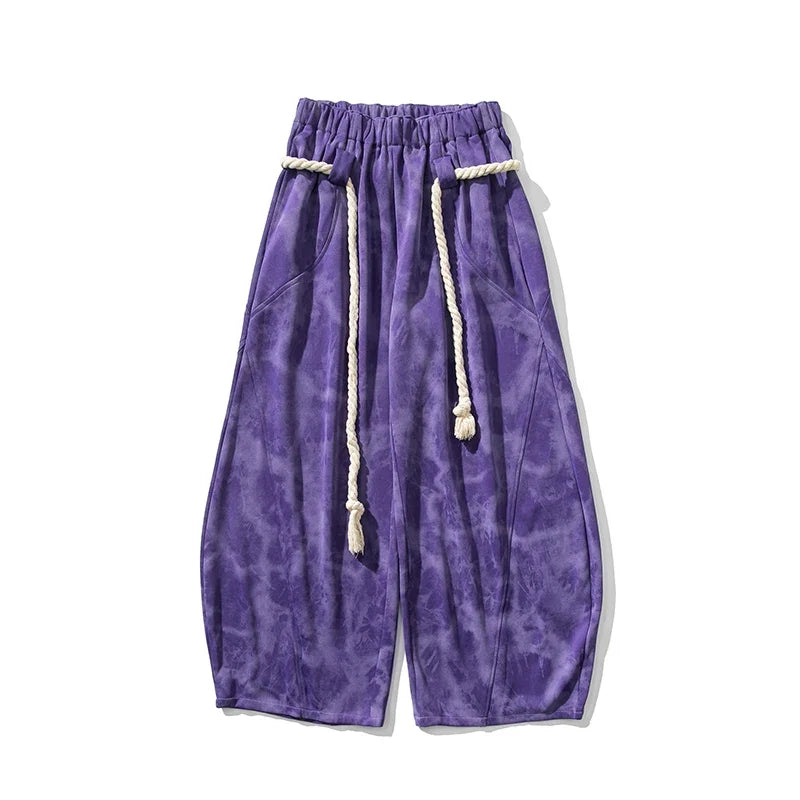 Textured women's flowing wide-leg pants, cinched with a fashionable rope belt, enhancing a stylish outfit.