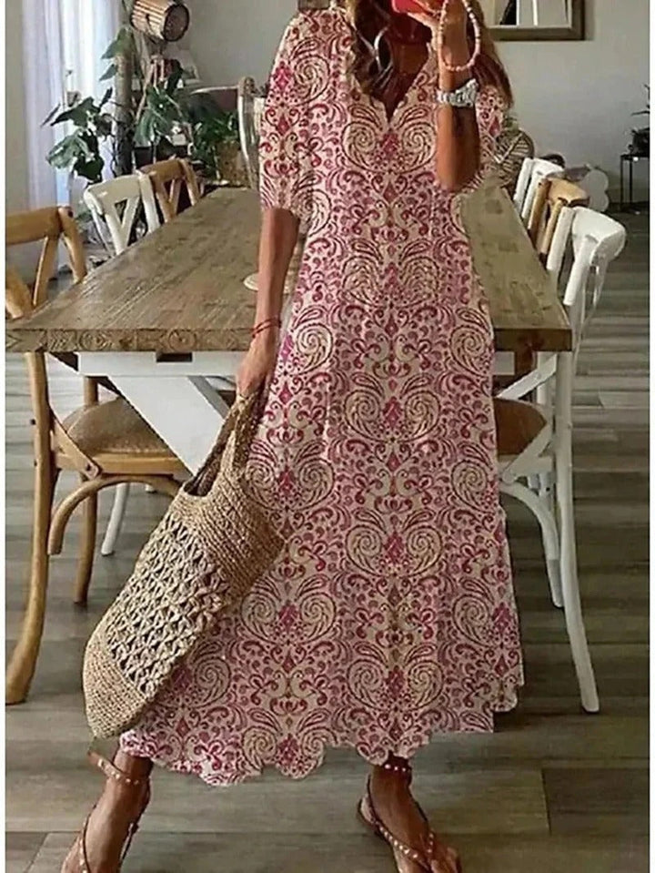 Flowy women's boho maxi dress, V-neck, three-quarter sleeves, elegant patterned design for summer.
