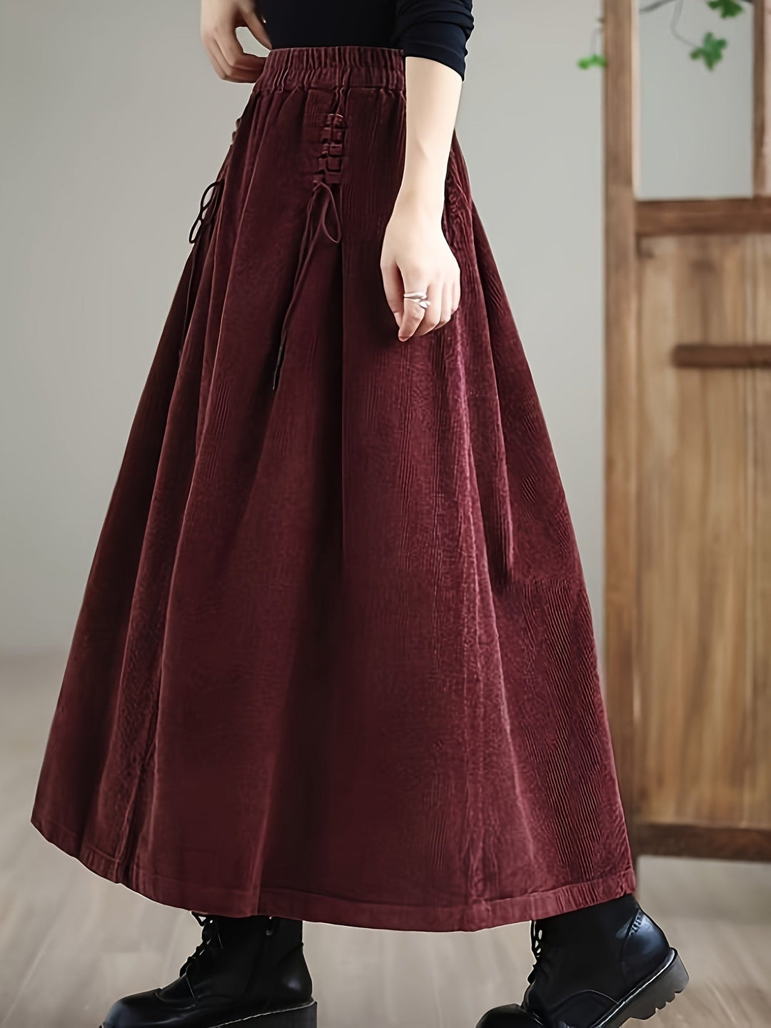 Woman modeling a casual flowy green maxi skirt with a unique corset waist and comfortable fit.