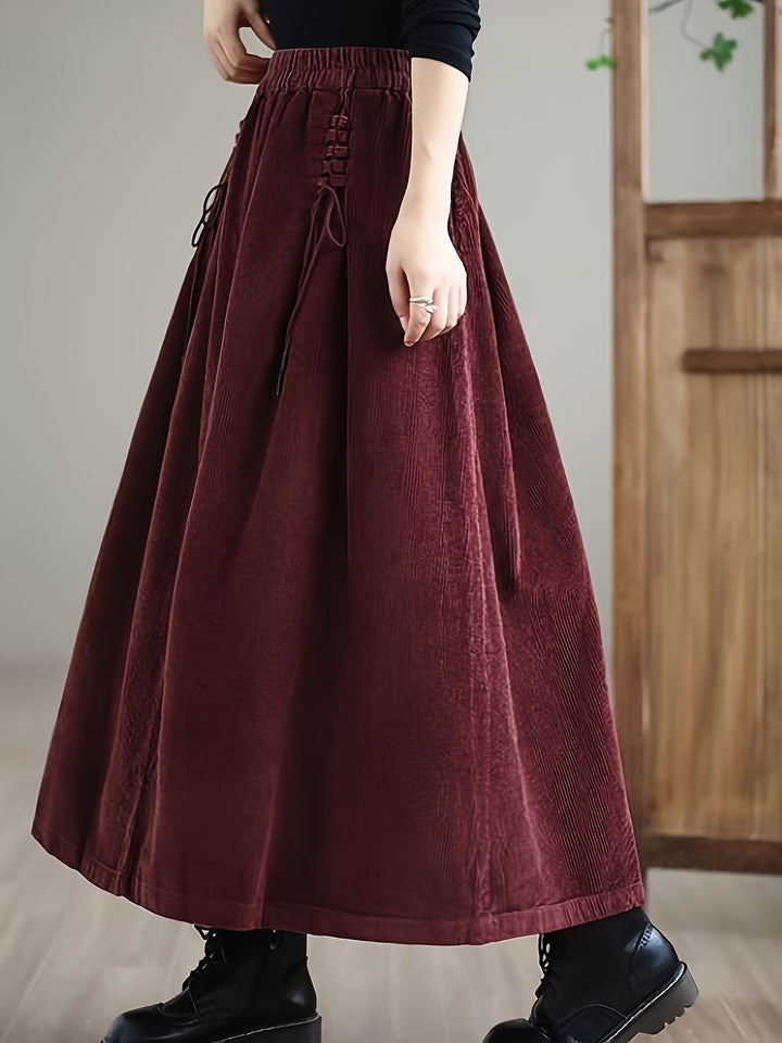 Woman modeling a casual flowy green maxi skirt with a unique corset waist and comfortable fit.
