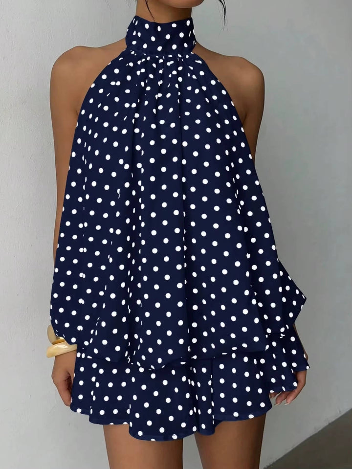 Women's summer halter mini dress with flowy ruffles & open back, styled for a chic party look.
