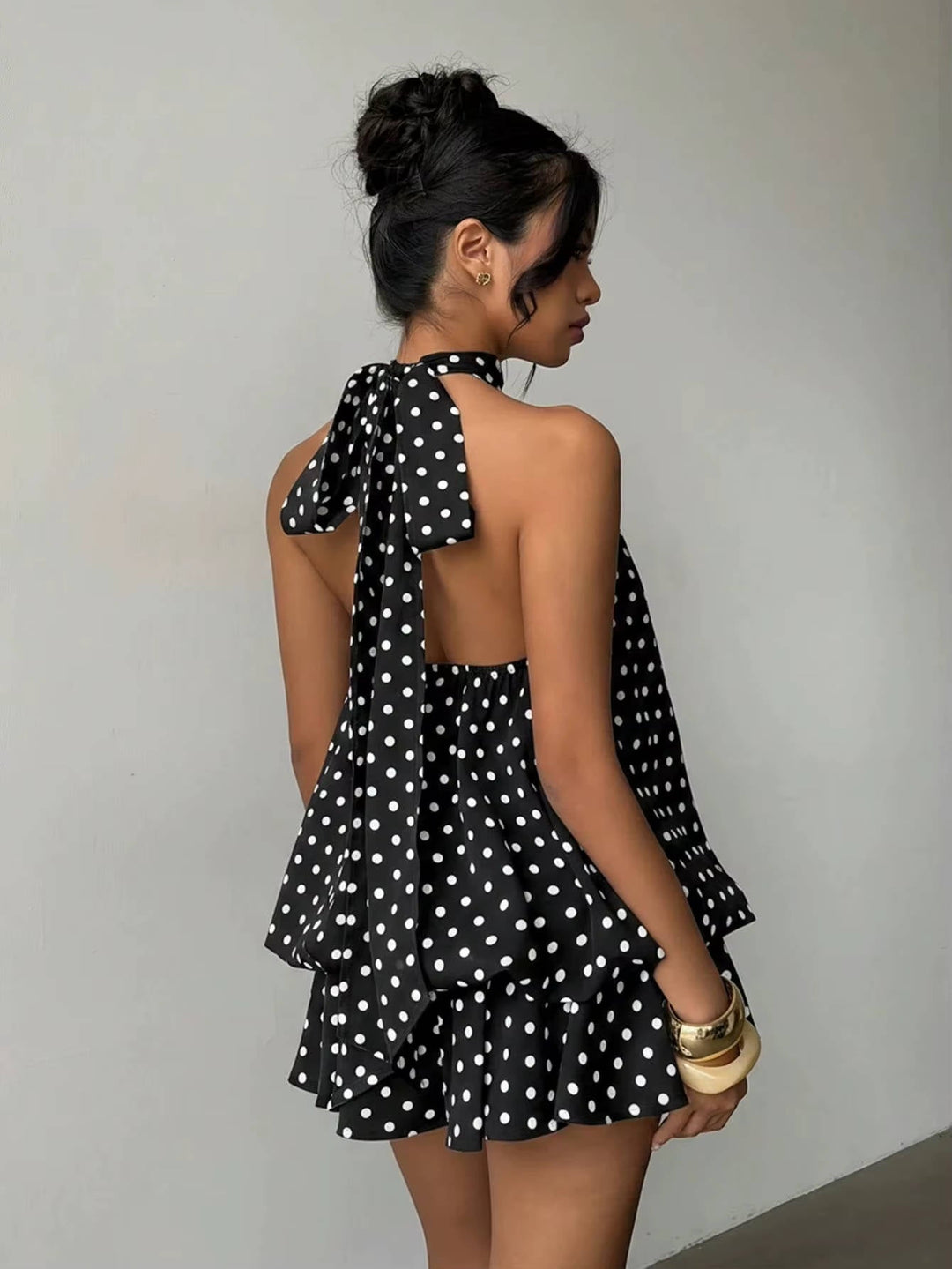Stylish women's flowy ruffle halter mini dress, showcasing an elegant open back, perfect for parties.