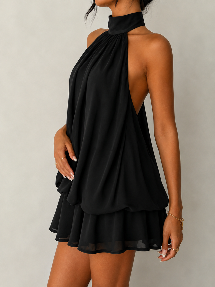 Flattering trapeze silhouette on a women's flowy halter mini dress with an alluring open back.