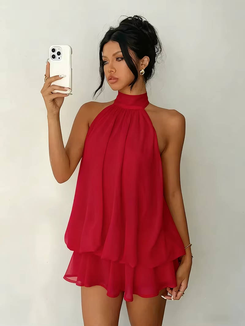 Model wearing a women's flowy halter mini dress with a captivating open back, ideal for summer fashion.