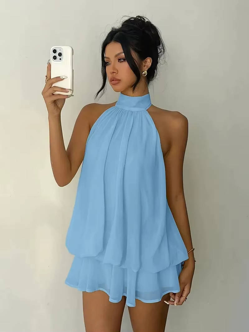 Close-up of the delicate ruffle hem on a women's flowy mini dress with a stylish halter neck design.