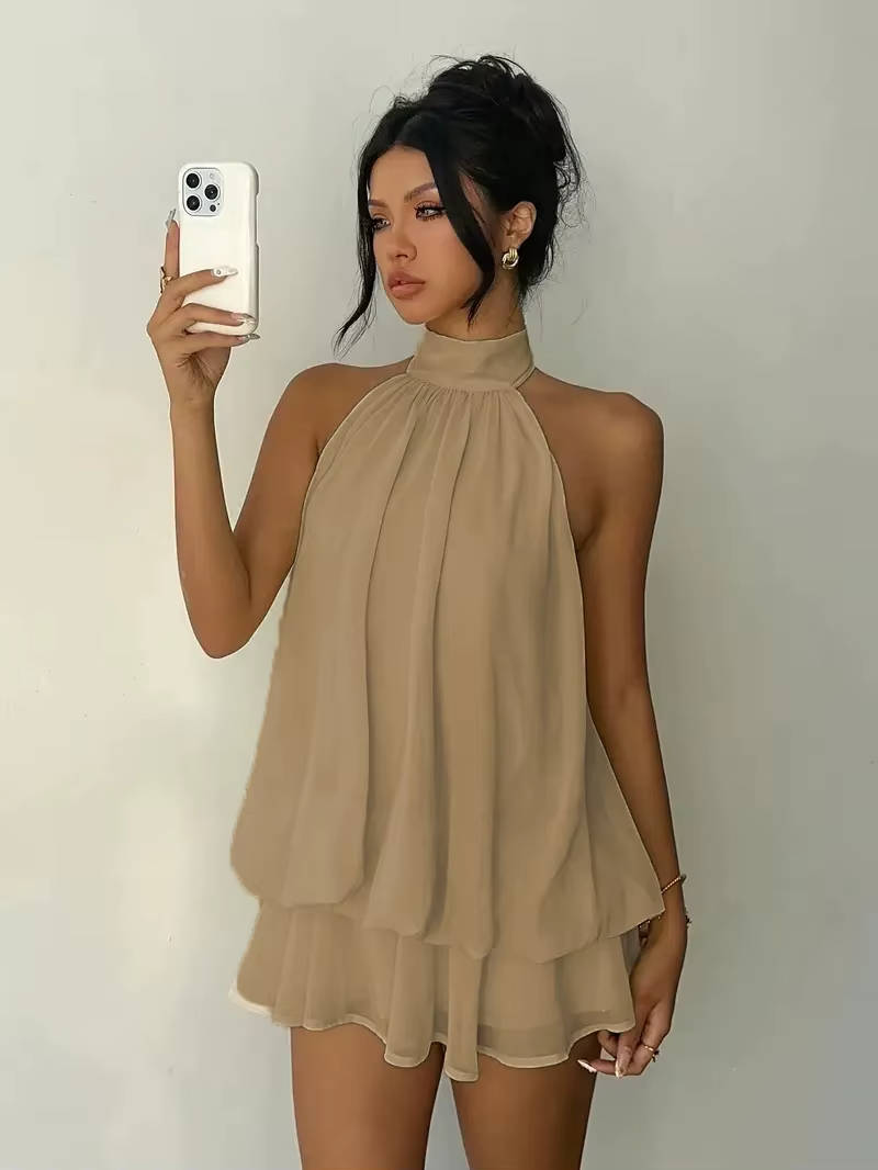 Back view of the elegant open-back design on a women's halter neck mini dress with flowy ruffles.