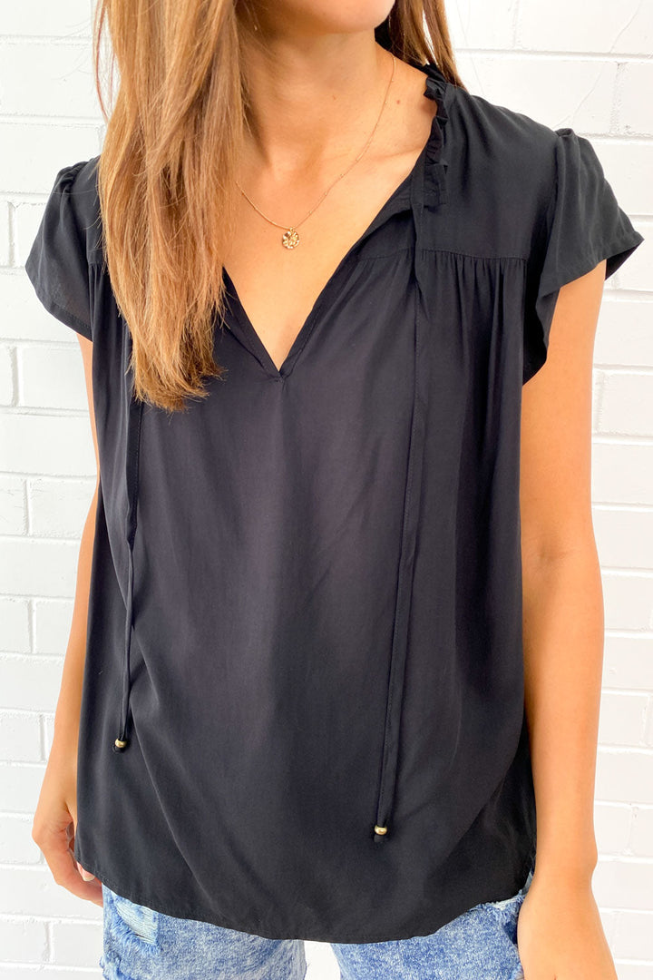 Relaxed fit women's sleeveless V-neck summer top, featuring a breezy flowy design and chic fringe.
