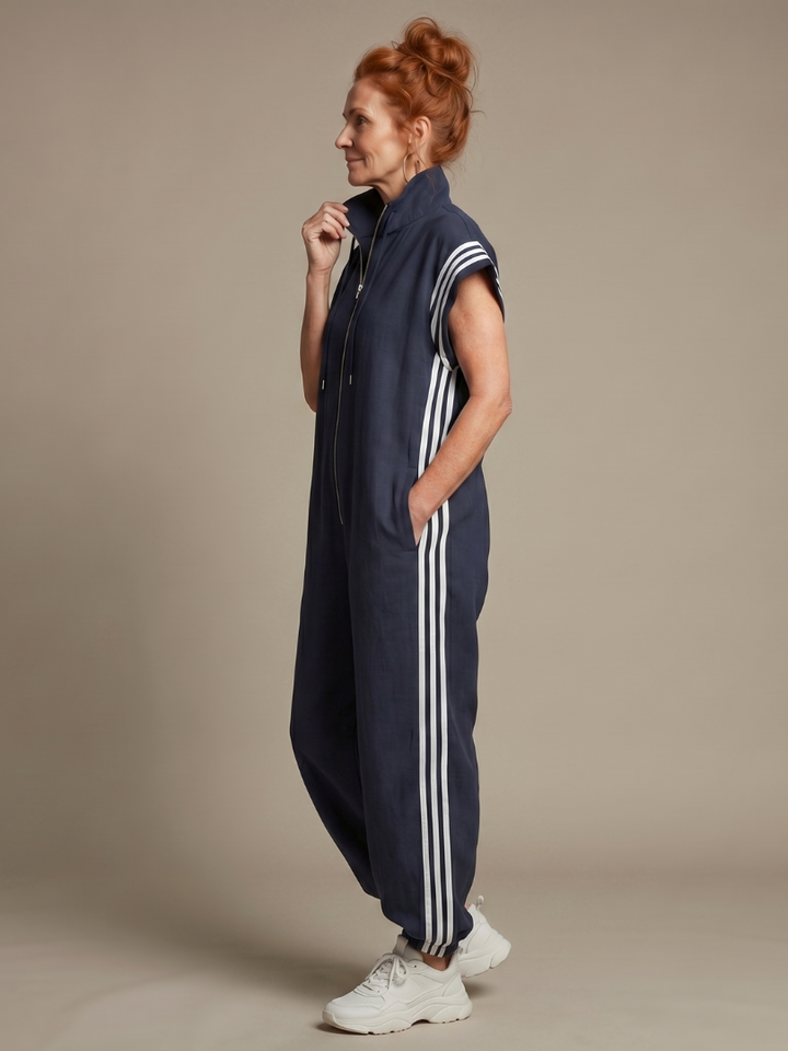 Women's full-length sporty jumpsuit. Features a zip front, high neck, and eye-catching side stripes.