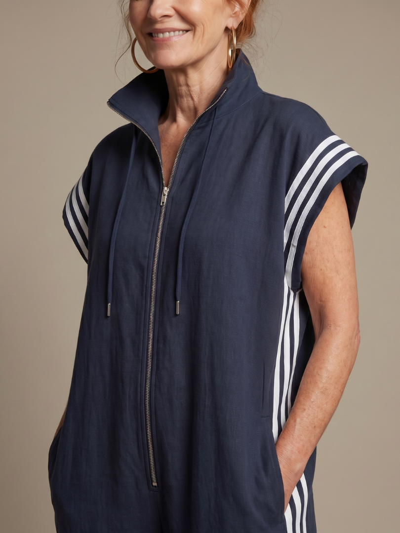 Relaxed fit women's full-length jumpsuit with a zip front, cap sleeves, & athletic side stripe detail.