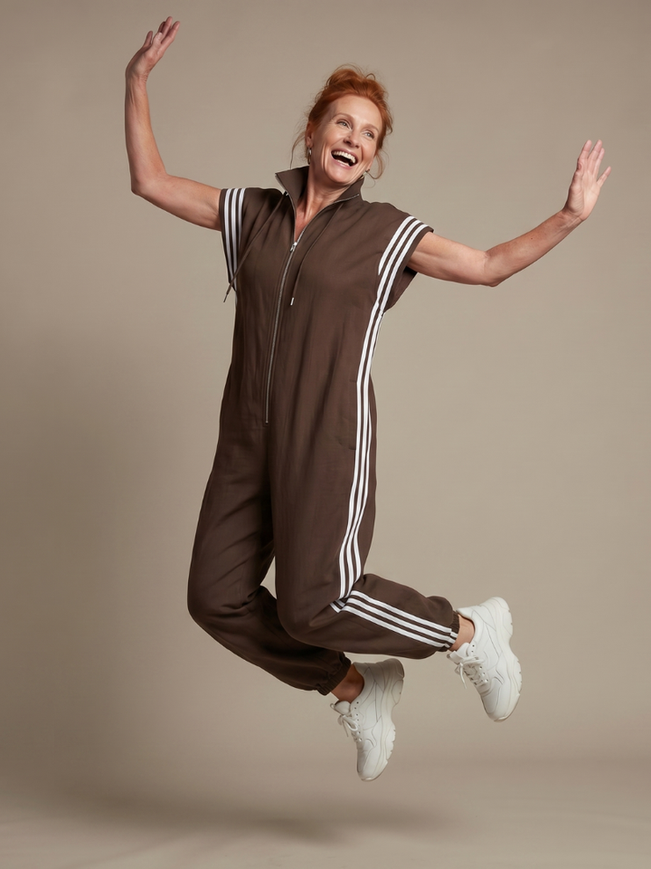 Modern women's full-length jumpsuit. Zip-up, cap sleeves, comfortable design, and sporty side stripes.