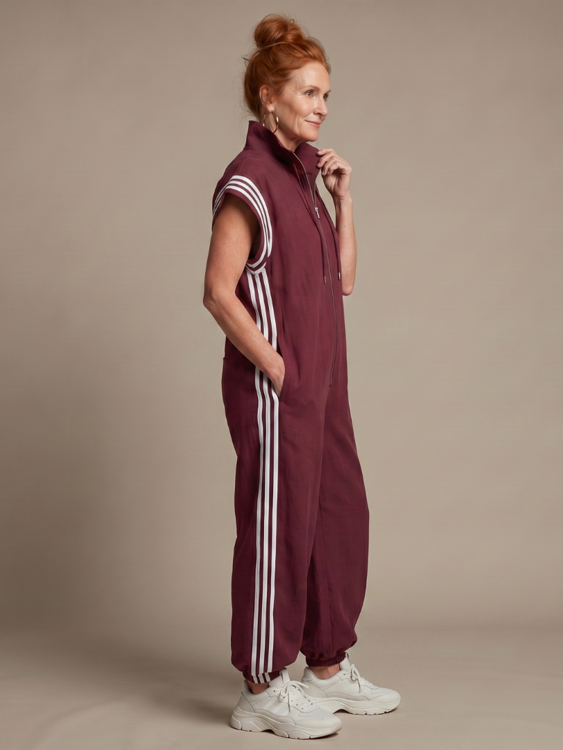 Comfortable women's full-length jumpsuit. Features a zip front, high neck, cap sleeves & side stripes.