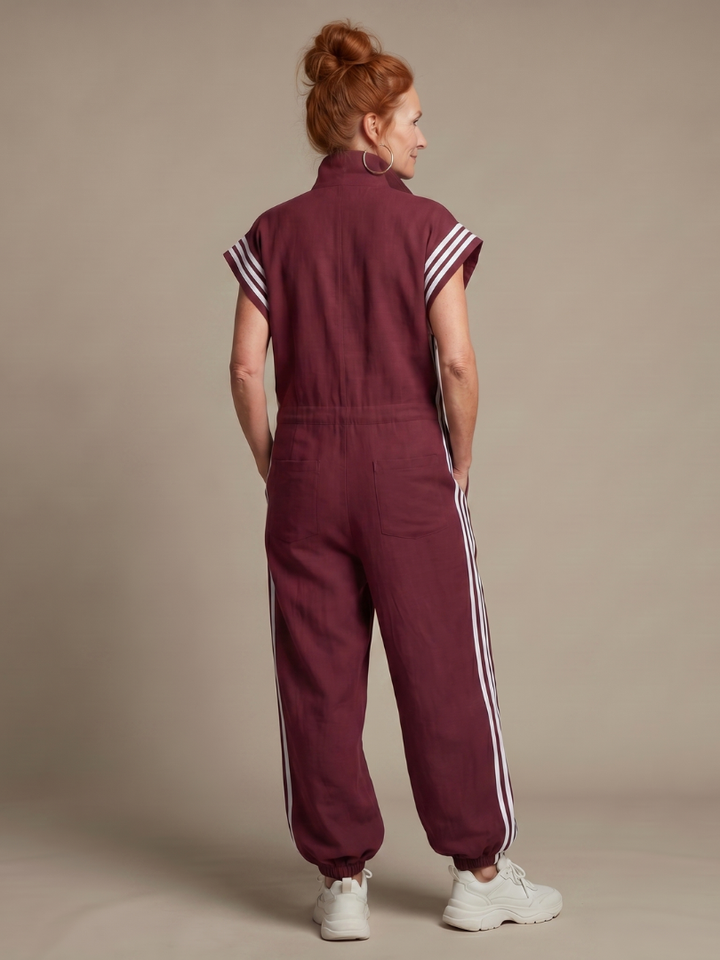 Relaxed fit women's full-length jumpsuit. Cap sleeves, zip front, and stylish athletic side stripes.