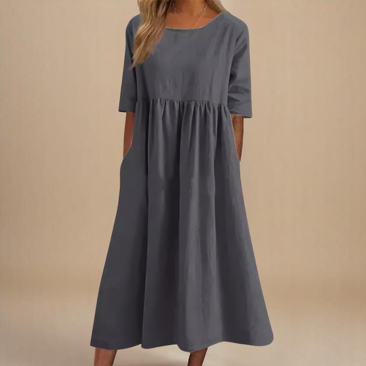 Flowy scoop neck midi dress for women, featuring gathered waist, half-sleeves, and practical pockets.