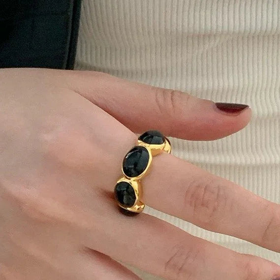 Women's gilded onyx gemstone ring. Elegant gold-plated jewelry with a striking black onyx stone. Versatile fashion accessory.