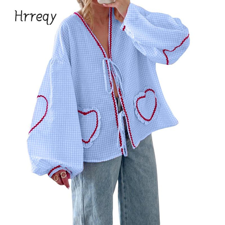 Women's gingham blouse with tie-front, heart pockets, and voluminous sleeves. Stylish & chic.