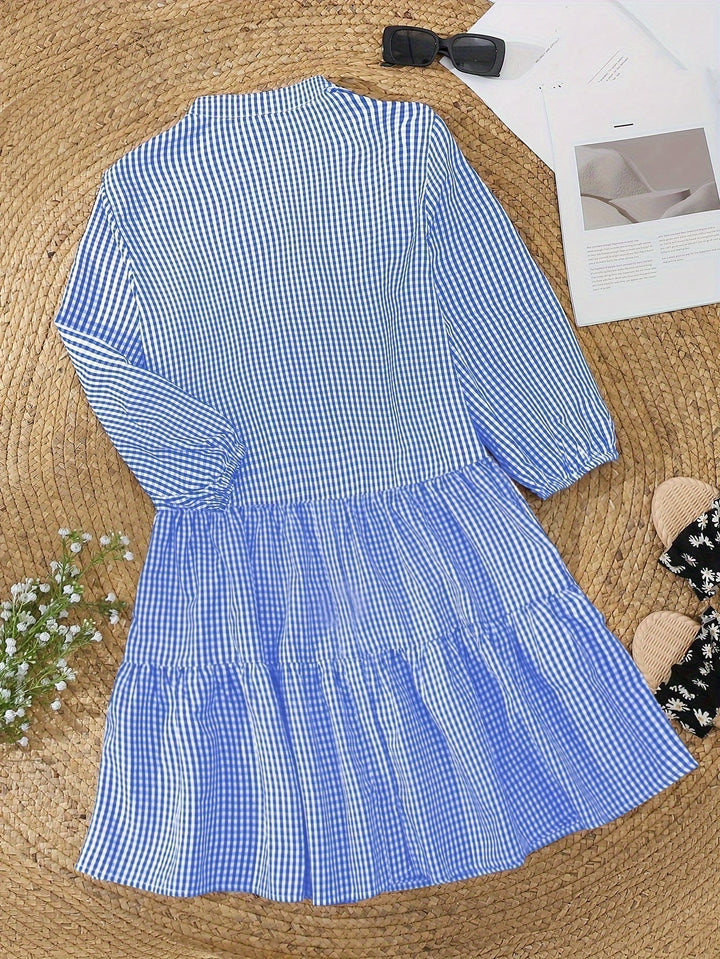 Effortless summer dress: a stylish gingham tiered mini dress with casual puff sleeves and ruffle hem.