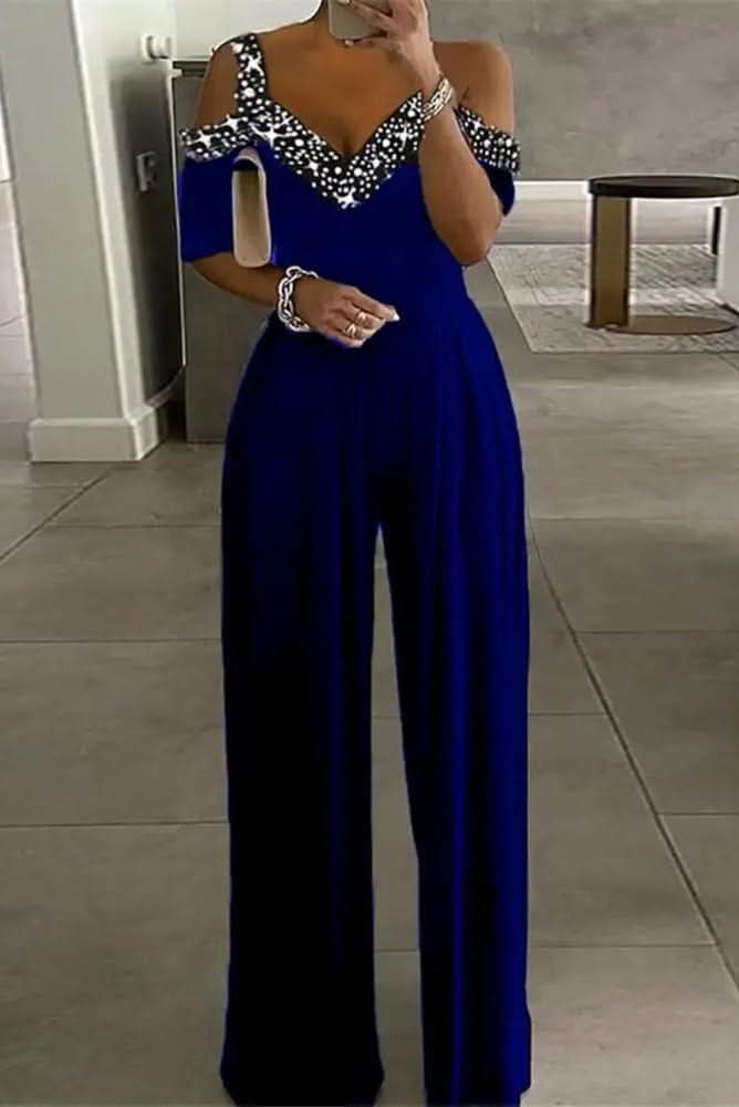 Elegant women's black jumpsuit featuring sparkling rhinestones. Sophisticated evening wear for a glamorous party look.