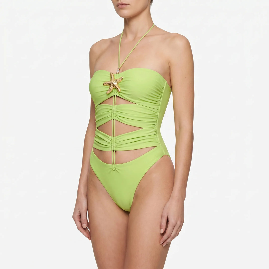 Glamorous women's cutout one-piece swimsuit, flat lay showing design and starfish details. Beachwear.