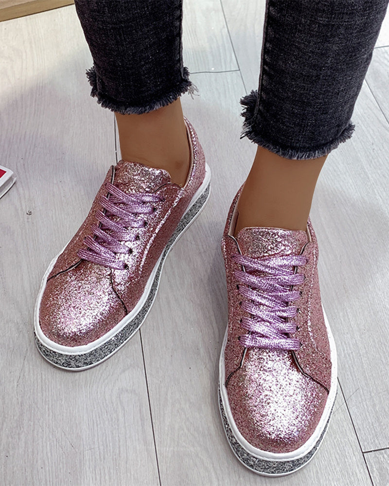 Close-up of women's sparkling glitter platform sneakers, highlighting texture and elevated sole.