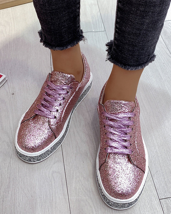 Close-up of women's sparkling glitter platform sneakers, highlighting texture and elevated sole.