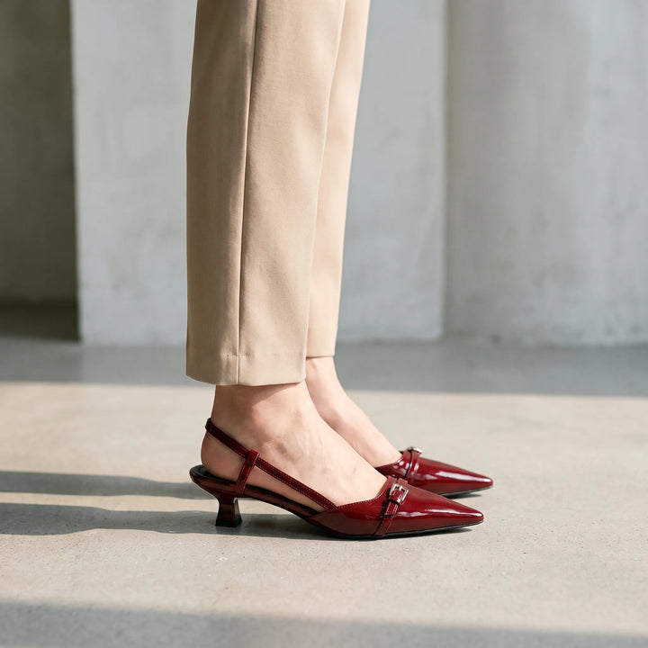 Women's glossy black pointed toe slingback kitten heels, perfect for formal or office wear.