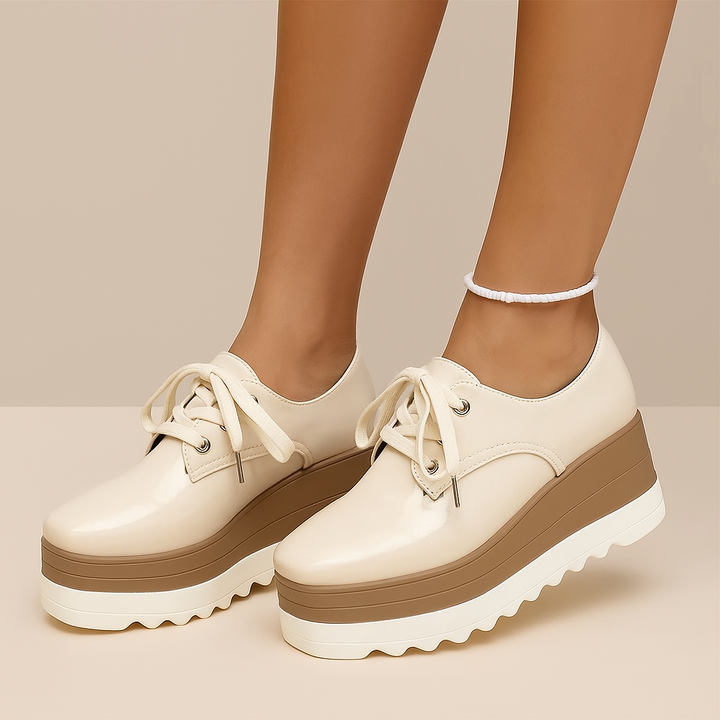 Close-up of the glossy finish on women's white platform sneakers, highlighting premium material & shine.