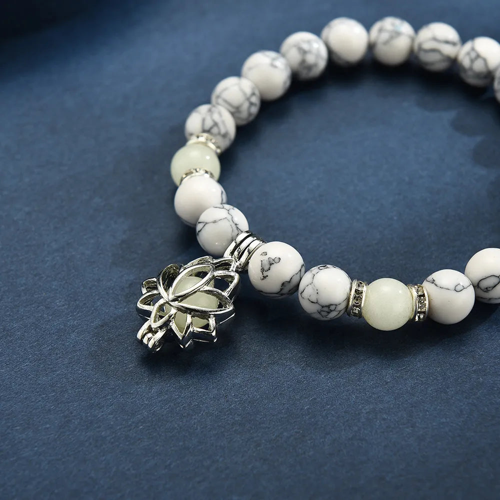 Detailed view of women's luminous lotus charm bracelet, glows beautifully in dark.