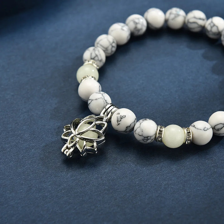 Detailed view of women's luminous lotus charm bracelet, glows beautifully in dark.