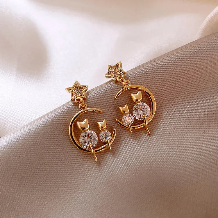 Sparkling gold cat ear earrings for women, featuring brilliant zirconia gems. Chic feline studs for any animal lover.