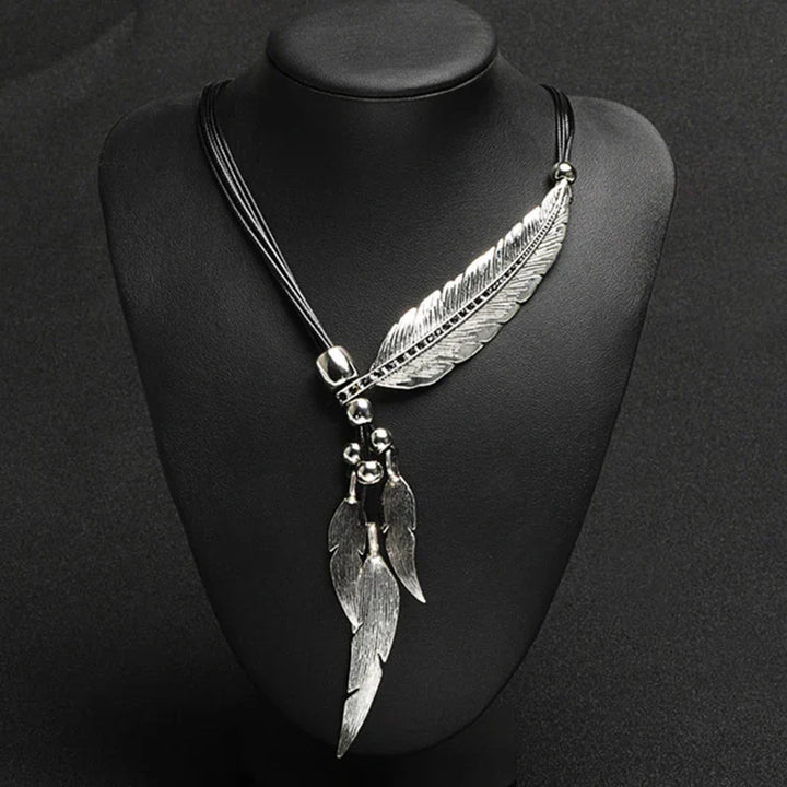 Delicate gold feather necklace. Boho style women's jewelry featuring a detailed feather pendant, a perfect gift for her.