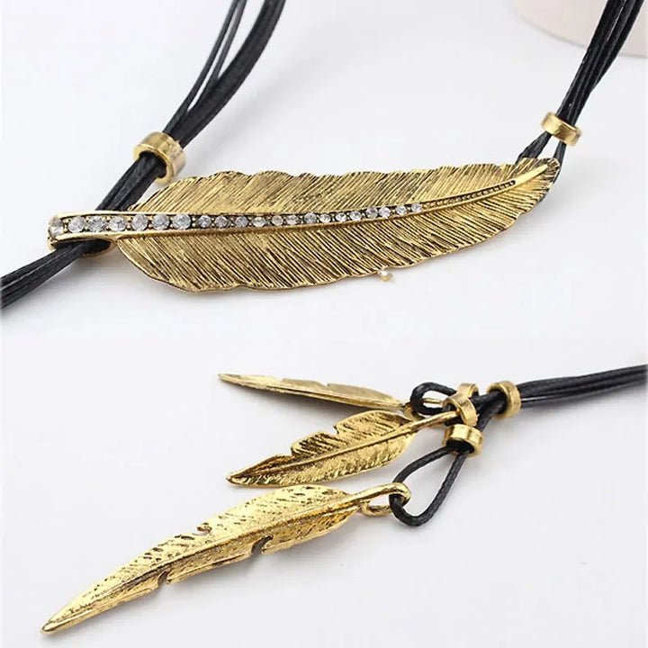 Shiny gold feather charm necklace. Trendy women's bohemian jewelry, ideal for layering or as a standalone statement.