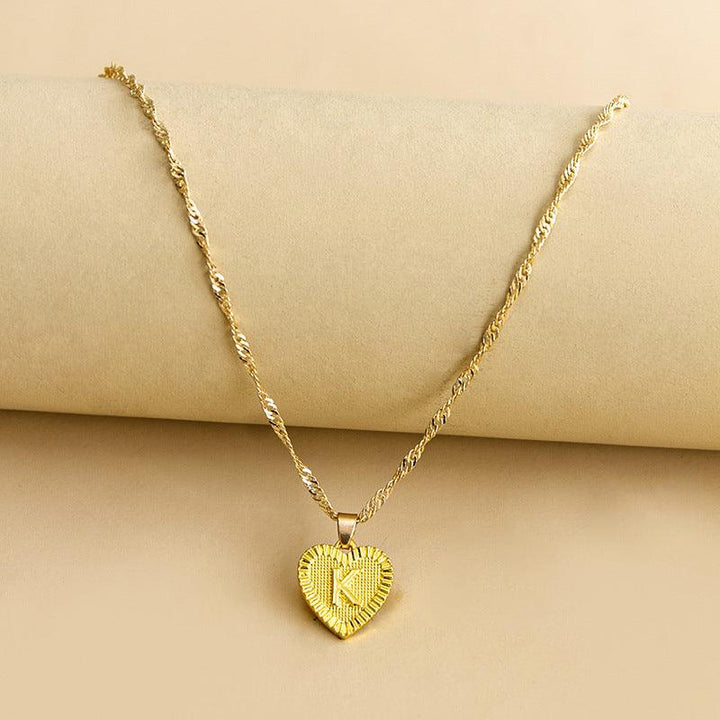 Women's personalized gold heart pendant necklace with an elegant initial.