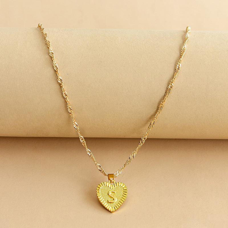 Elegant women's gold initial heart pendant, showcasing fine craftsmanship.