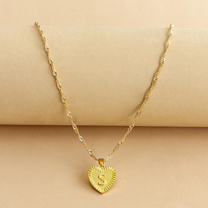 Elegant women's gold initial heart pendant, showcasing fine craftsmanship.